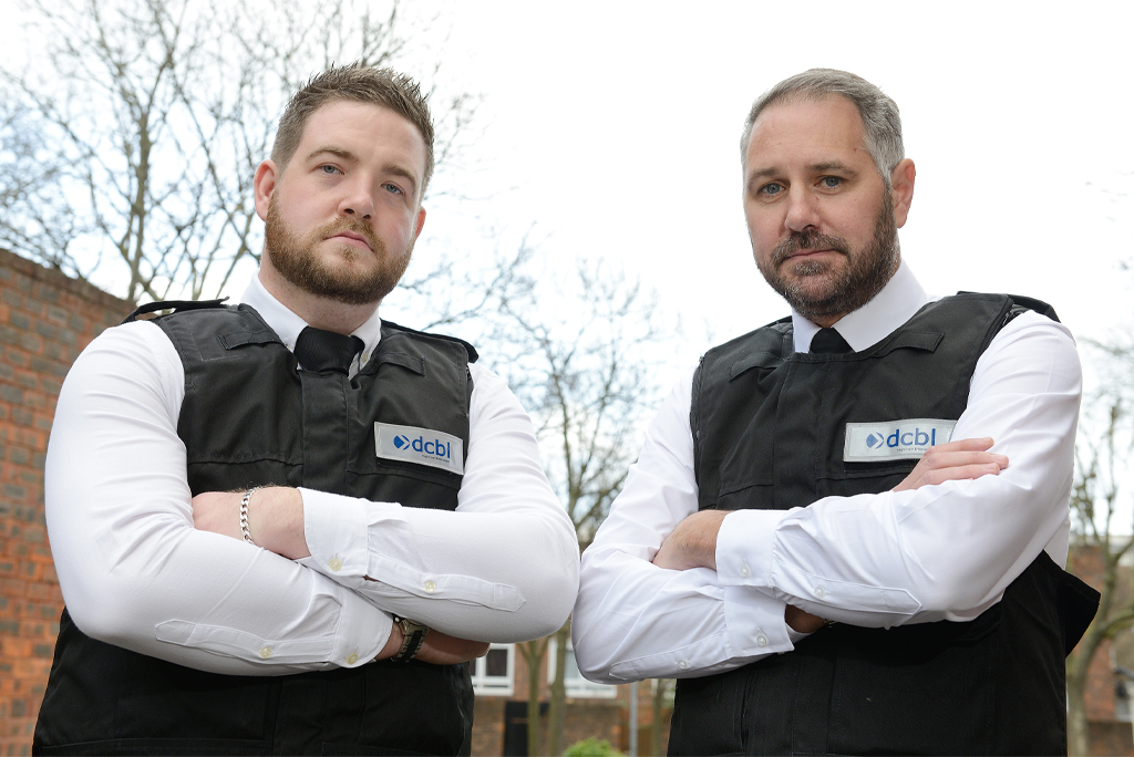 Can’t Pay? We’ll Take It Away! enforcement officers in white shirts, black tie and jackets with arms folded