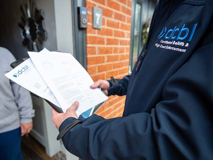 DCBL agent at open front door with papers