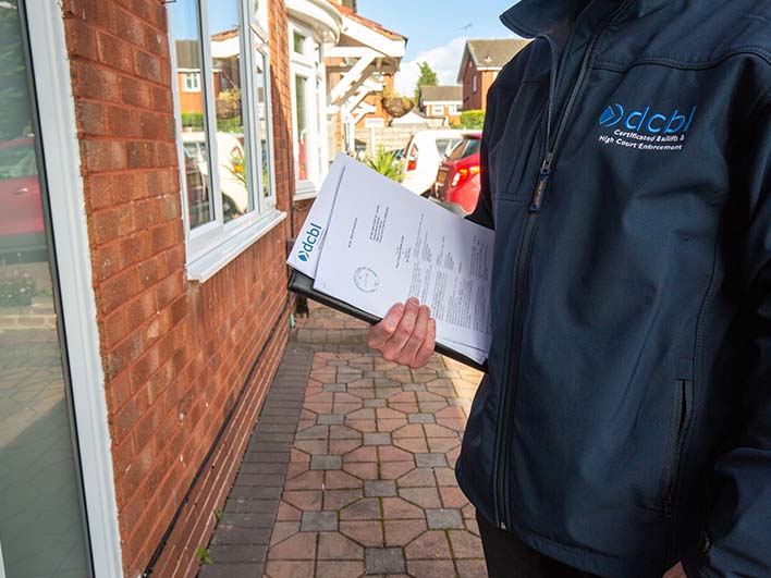 DCBL agent at front door with papers